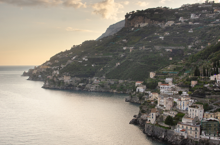 Sunset golden hour view of the Amalfi Coastline and Ravello from the Mortella Lookout in Minori. The image captures the enchanting sea view, revealing the picturesque coastline bathed in the warm hues of the setting sun.
