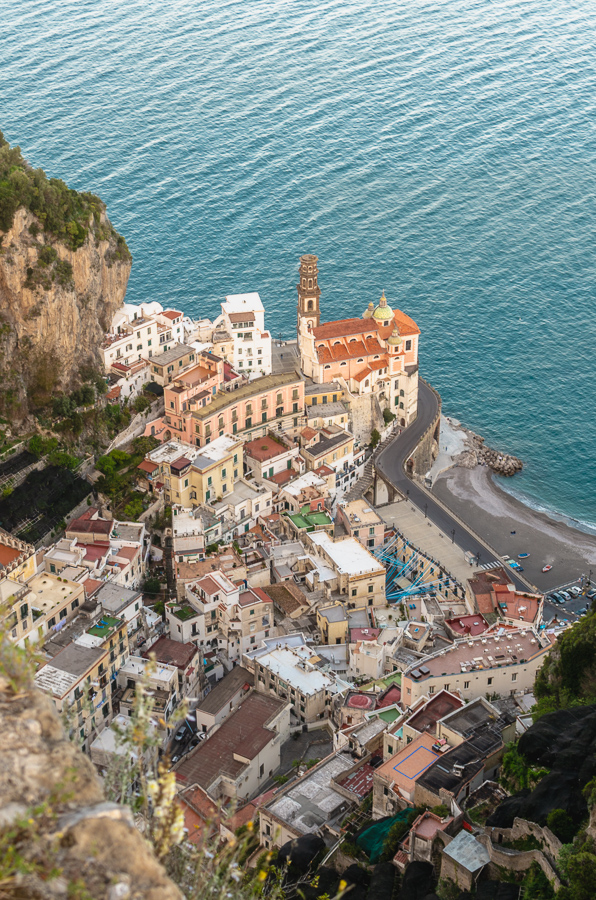 Atrani, the view of the little town above. Densely built houses, under rocky cliffs. The church and the belltower are dominating the view. The blue sea behind. No wonder filmmakers love this location.