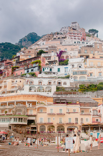 The Vertical City: view of creamy-colored houses cascading down the cliffs, above the Marina Grande in Positano, Italy.