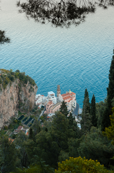 Atrani as seen from the panoramic point, on the path that leads to Torre dello Ziro. Aerial view of the little town, and the church. The blue sea behind. Forest in the foreground. 