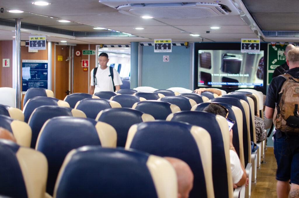 The interior of the ferry to Sorrento, featuring rows of blue and white couch-type seats.
