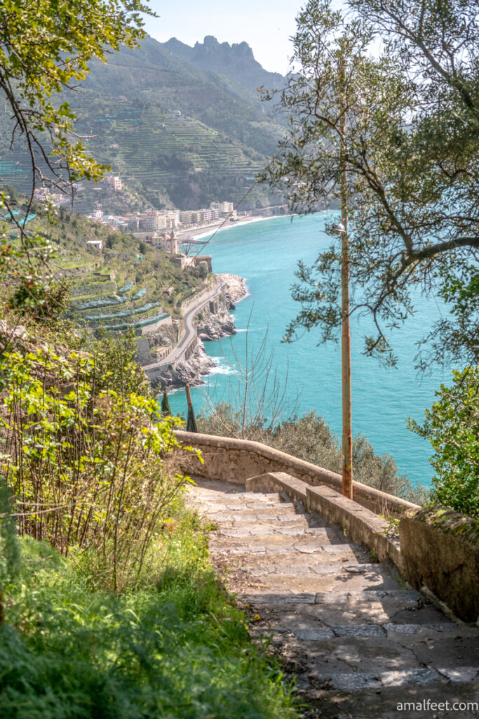 Stone staircase and terraced gardens in the Background. View of the coastline and the turquoise sea.
