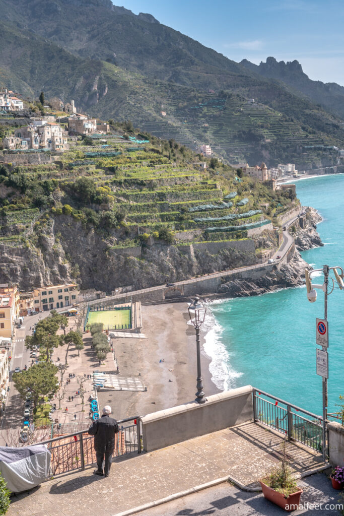 Panoramic point in Minori. Sidewalk balcony overlooking to the village of Minori. The beach and the promenade are visible under. Mountains and agricultural terraces are in the background. Turquoise coloured sea.