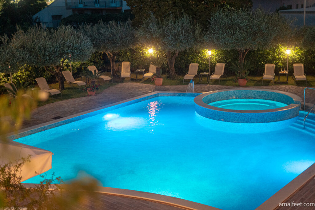 Hotel near the Archeological park of Velia. Illuminated swimming pool at the evening, with olive trees around.